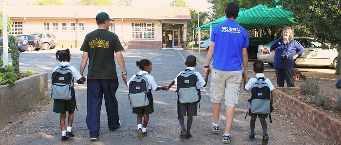 SOS Africa Founders Matt and Henry walking new sponsored children to school