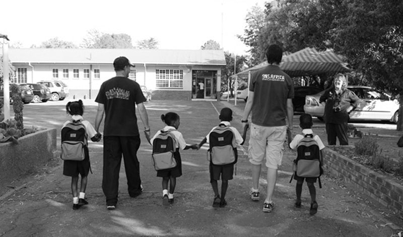 SOS Africa founders Matt & Henry walking sponsored children to their first days at school in 2006